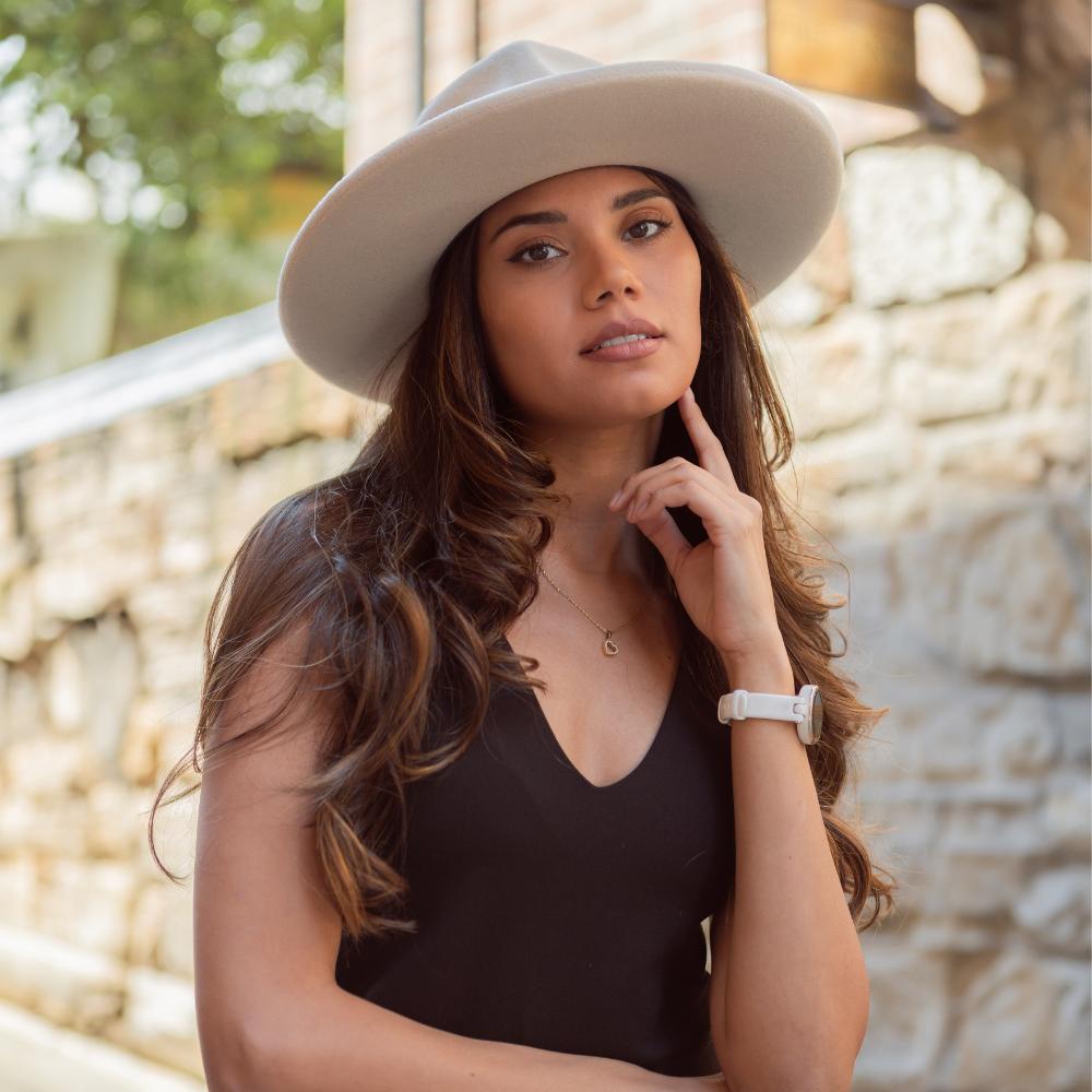 Model wearing Italian Felt Hat sitting in front of Sandstone Wall